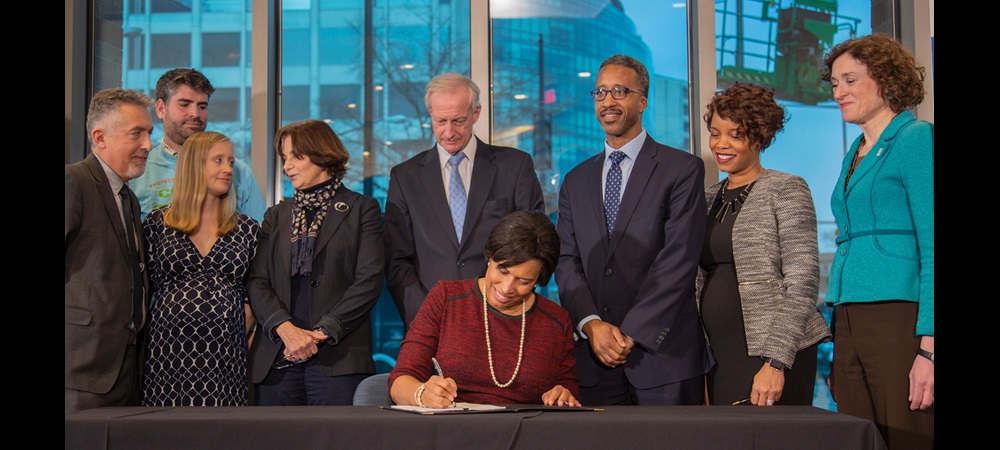 Mayor Boswer signing document in AGU office