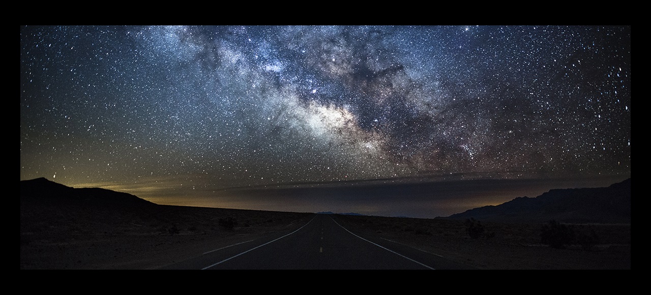 Night sky with the milky way and stars over an empty road, USA.