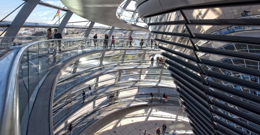 people walking on spiral staircase inside clear glass wall building on a sunny day. Bundestag, Berlin, Germany
