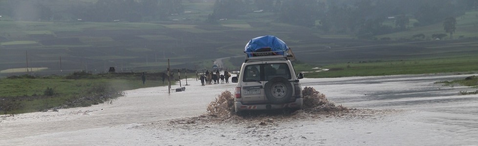 Back view of a truck driving through deep water after flooding. Africa