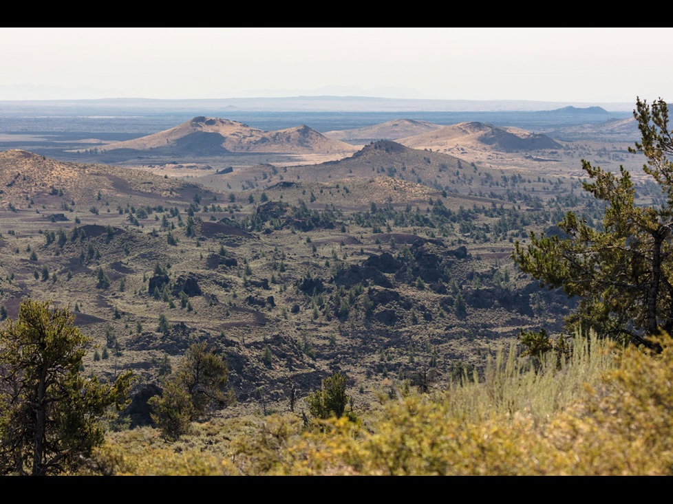 Landscape photo showing the volcanoes of Craters of the Moon National Monument in the distance