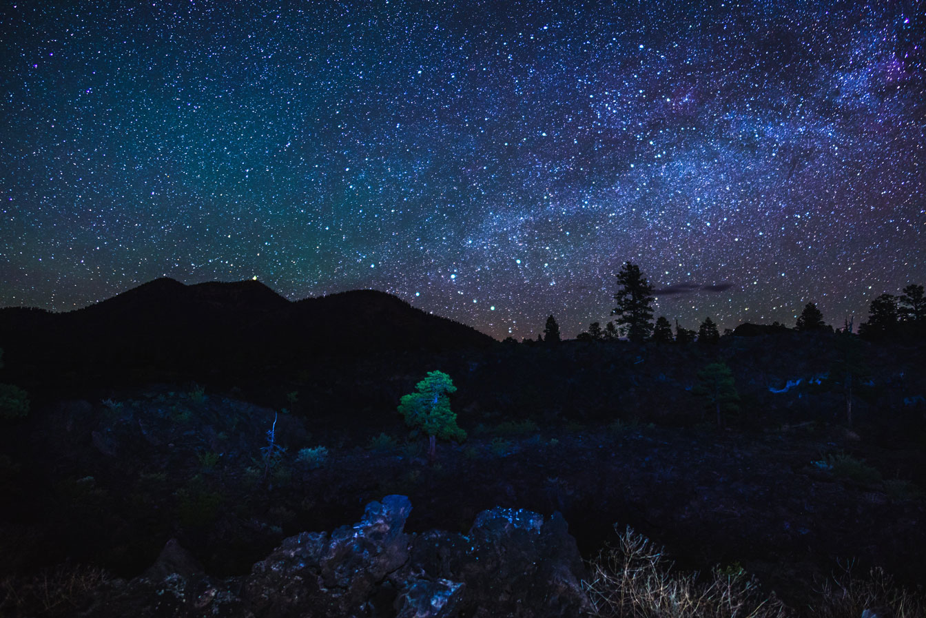 The night sky full of stars with the dark outline of O'Leary Peak at Sunset Crater National Monument