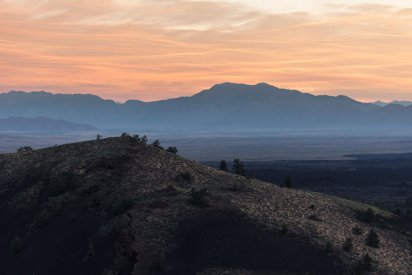 A sunrise behind a volcanic cone in Craters of the Moon National Monument