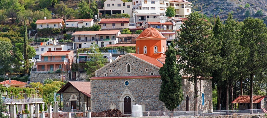 white houses with red roofs and church with red turret built on mountain