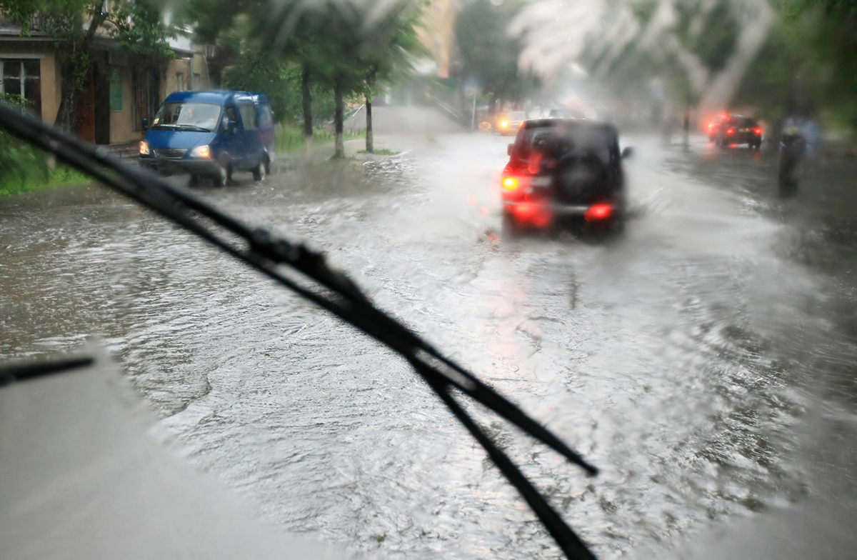 looking through the car window at a flooded road in the rain