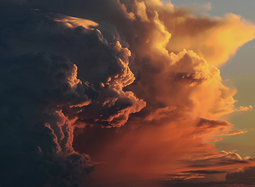large storm clouds with light cast by setting sun