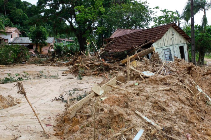 The remains of a small house after a mudslide, daytime, palm trees