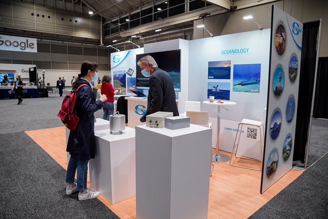 Oceanology exhibitor and attendee at booth at AGU December meeting