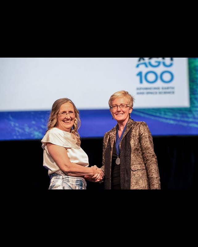 Woman fellow shakes hands with AGU president Robin Bell