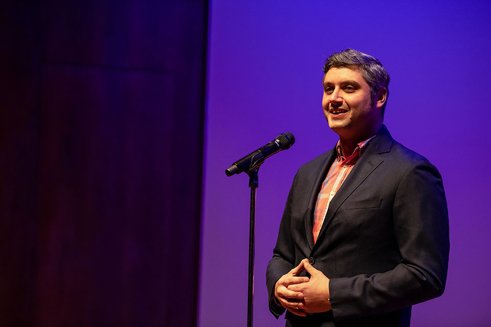 Man speaks into microphone Man speaks into microphone with purple background