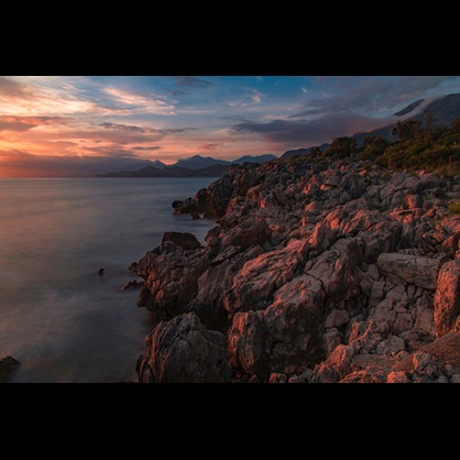 Rocky coastline with clouds and a pink lighting
