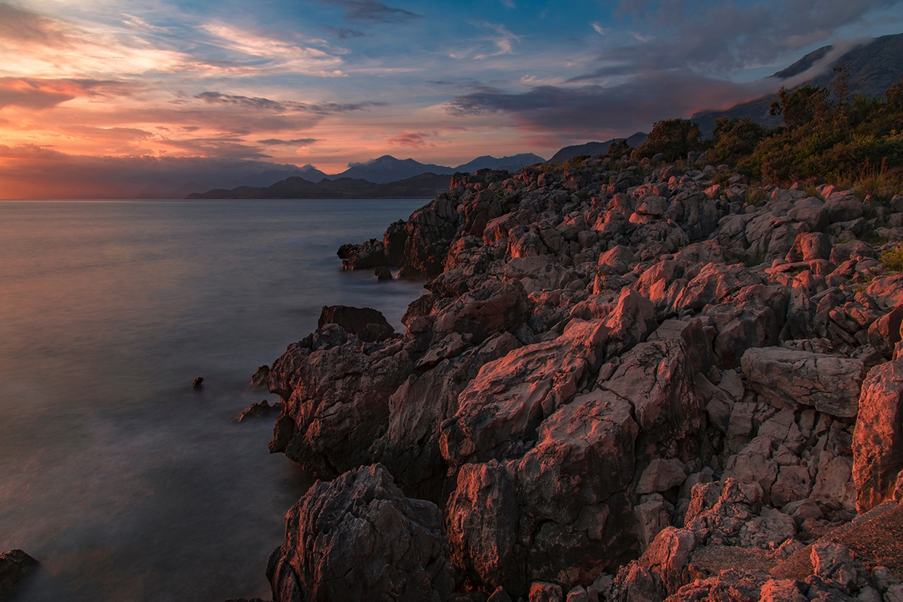 Rocky coastline with clouds and a pink lighting