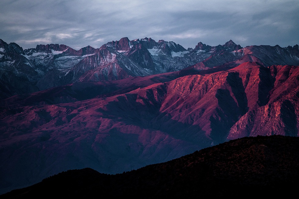 Mountain range at sunset under a cloudy sky