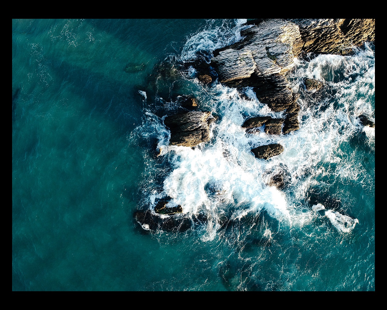 Waves crashing over rocky coastline