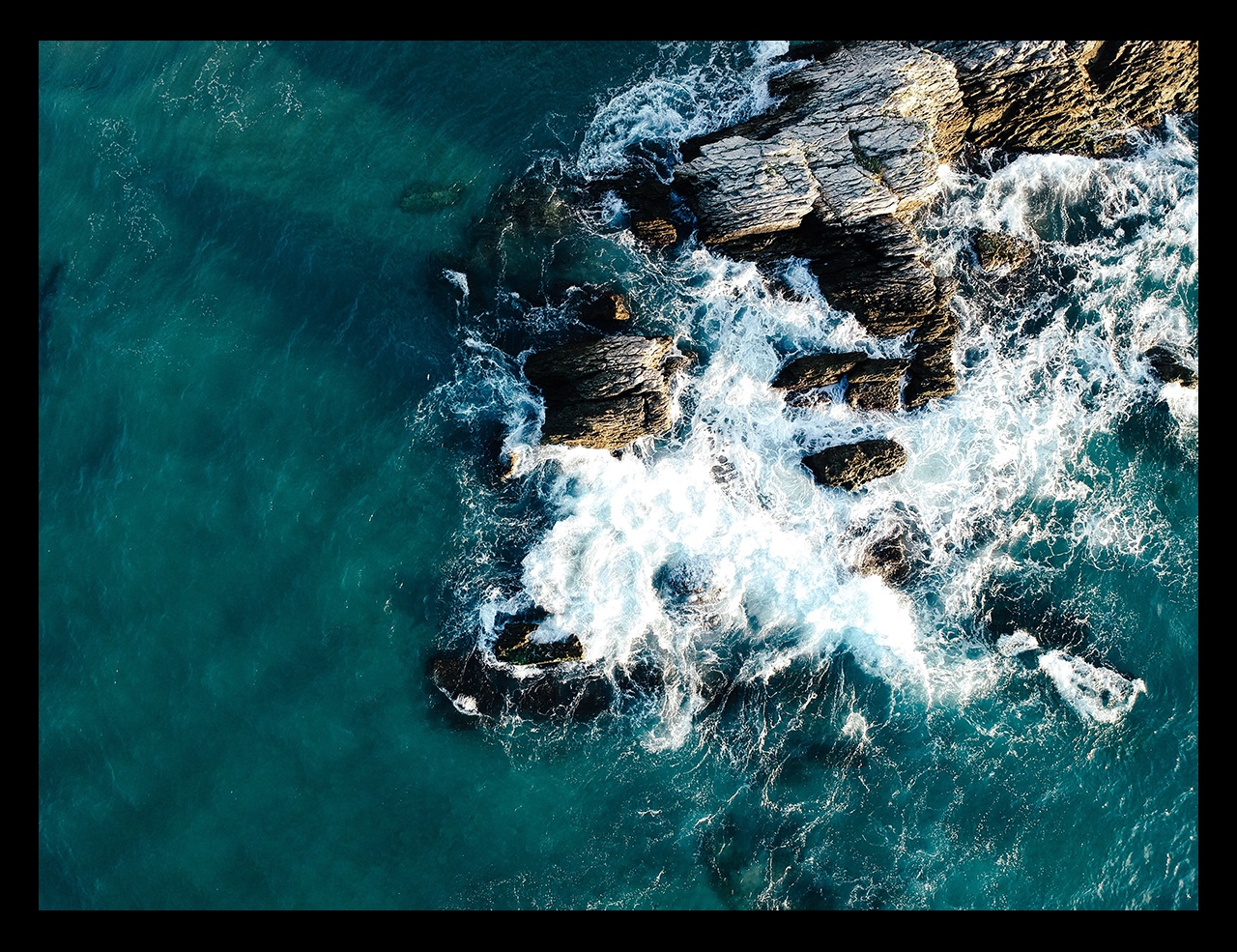 Waves crashing over rocky coastline