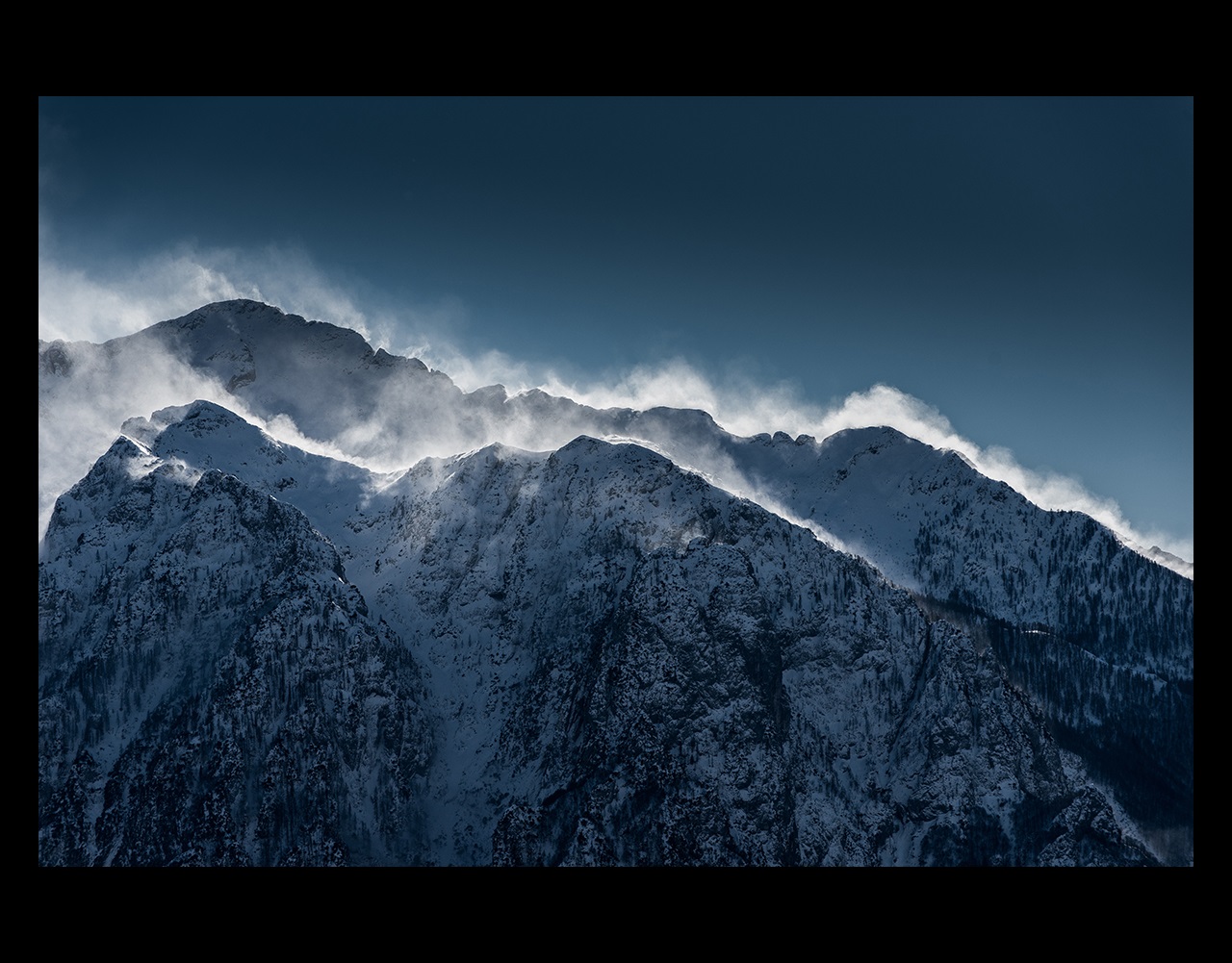 Snow blowing on top of mountain peaks