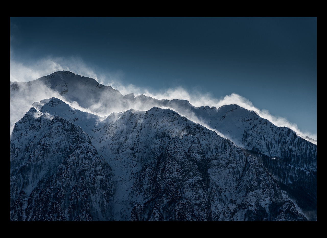 Snow blowing on top of mountain peaks