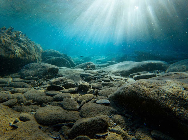 Underwater view of rocks with sunlight, Greece