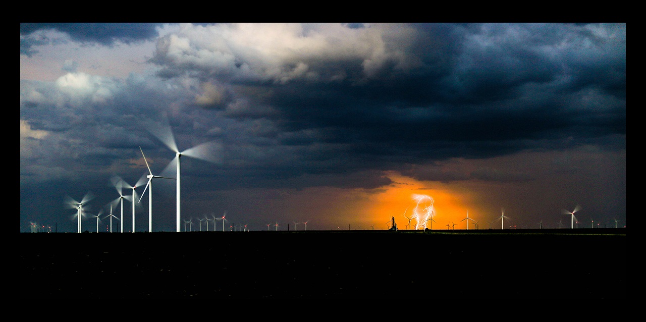 Wind turbines with lightning storm in background