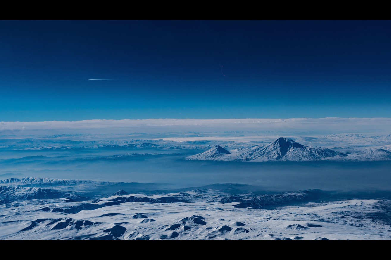 Looking out over cold snowy mountains from a plane