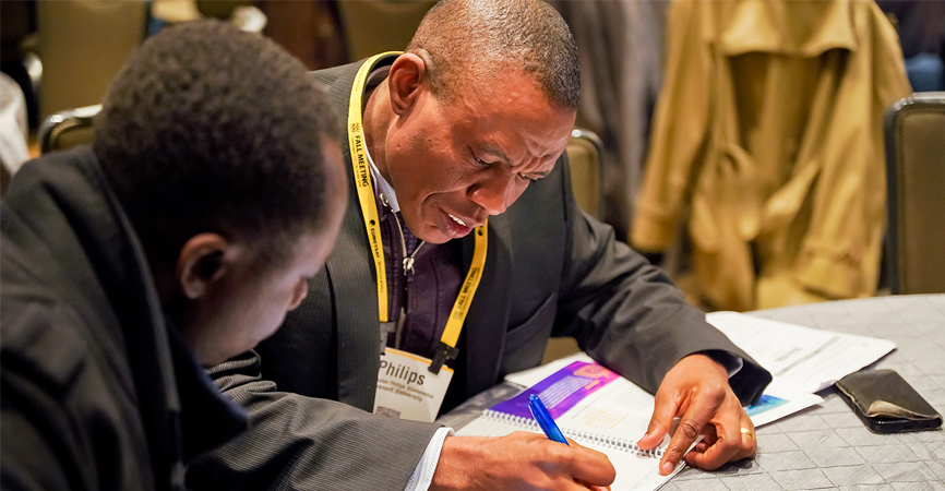 Two men in conversation at Fall meeting