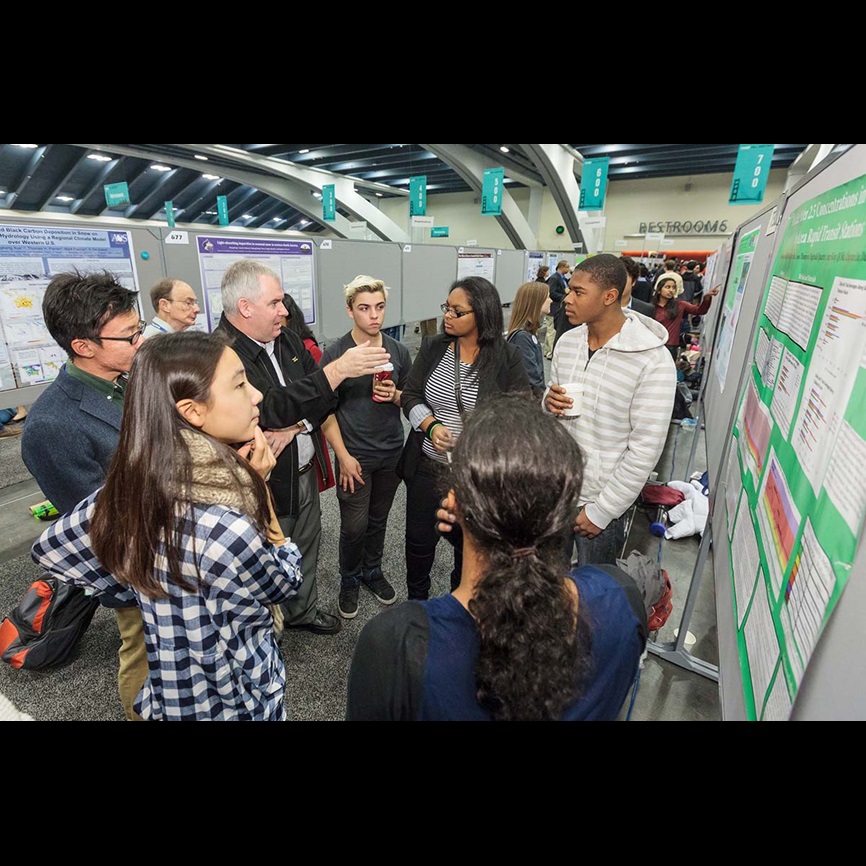 A group of students and teacher having a discussion in the poster hall