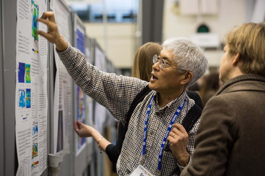 Man explaining and pointing at poster in Poster Hall