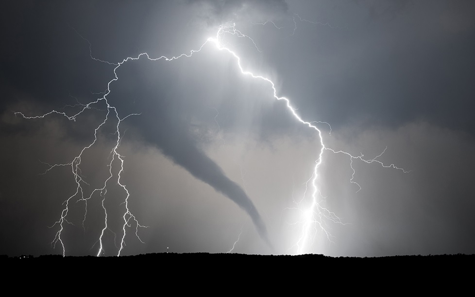 A thunderstorm producing a tornado and lightning.