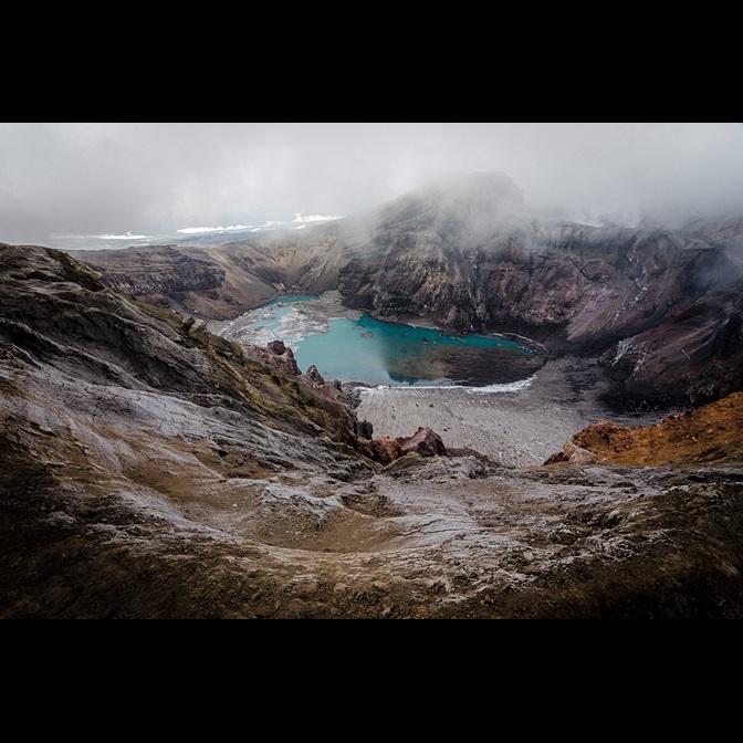 Lake at bottom of crater on a foggy day