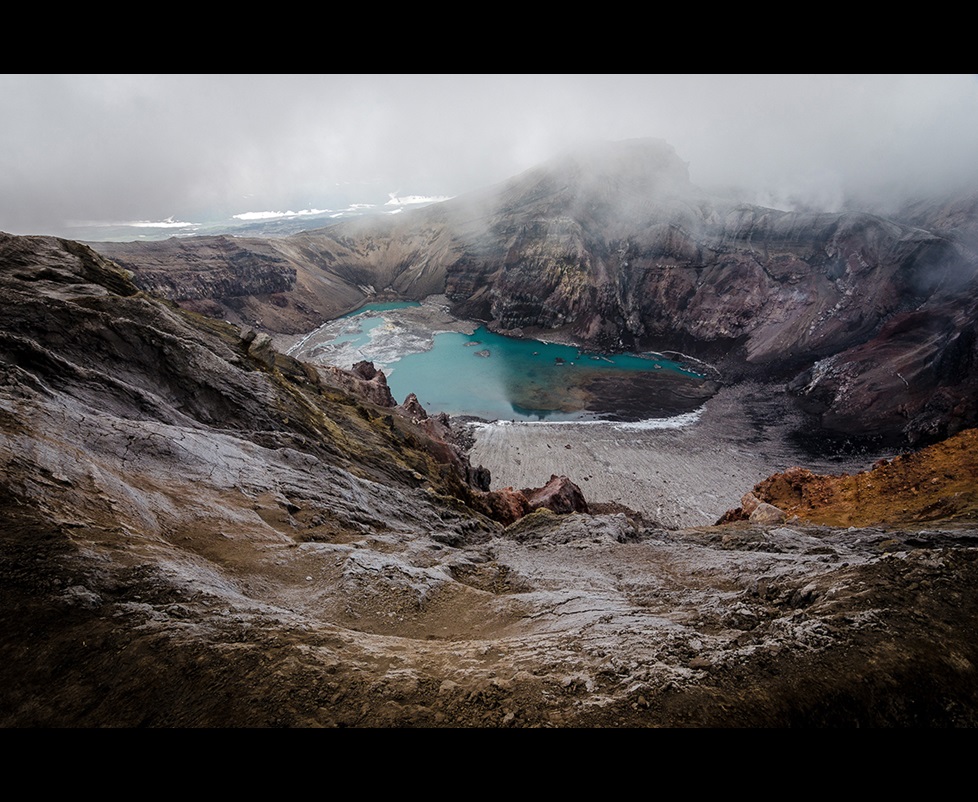 Lake at bottom of crater on a foggy day