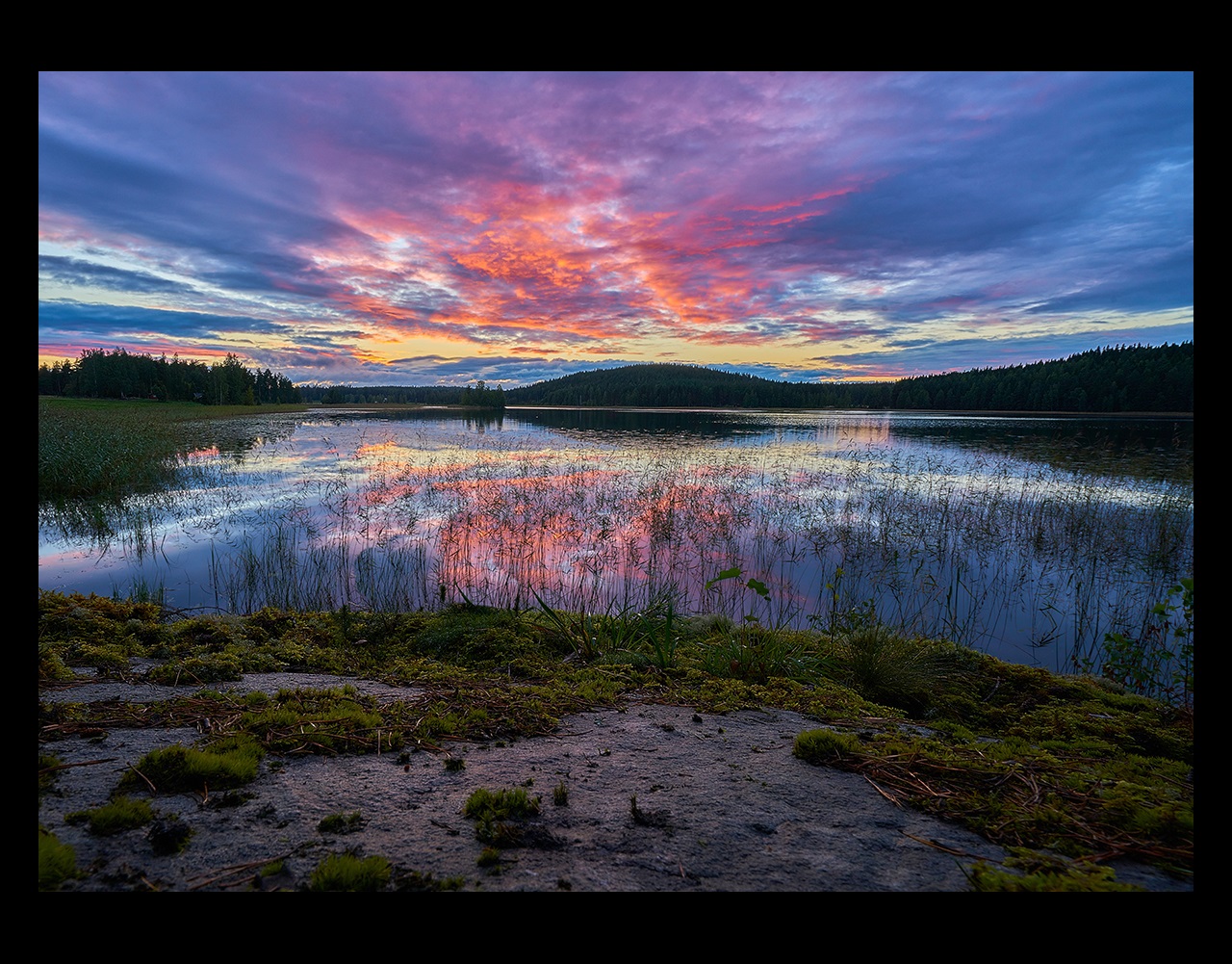 Lake with sunset and hills in background, Finland