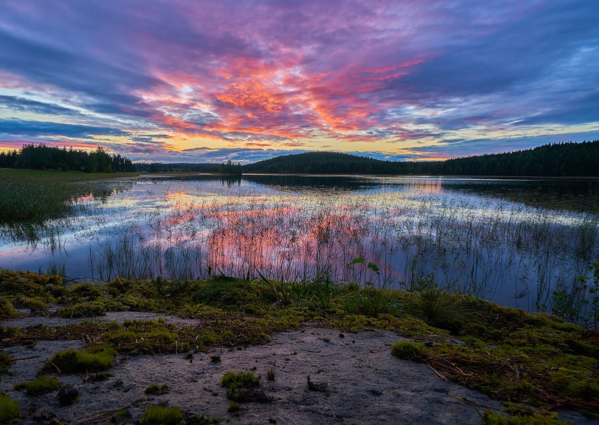 Lake with sunset and hills in background, Finland