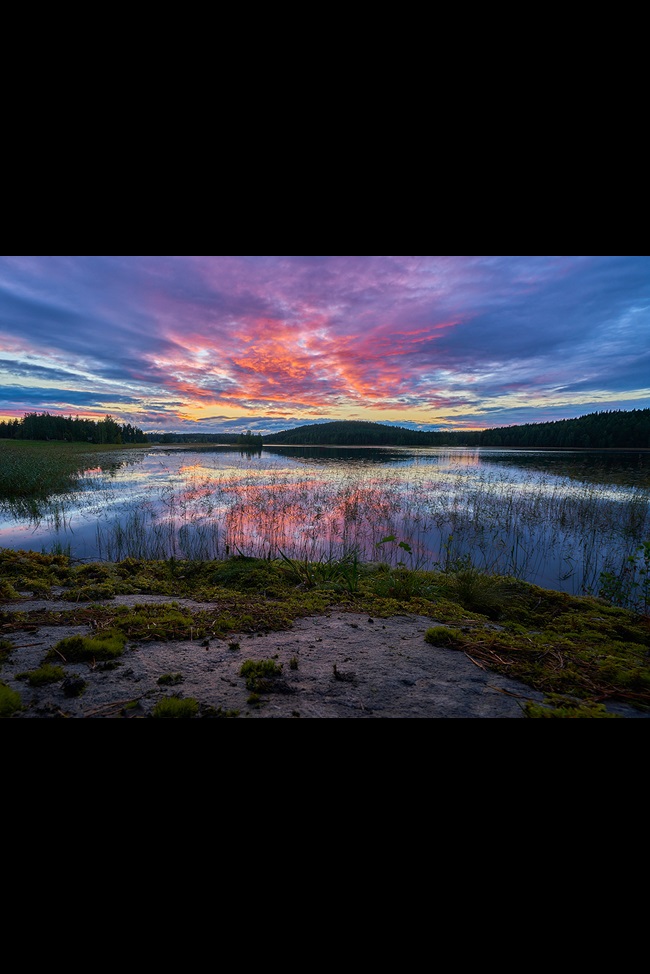 Lake with sunset and hills in background, Finland