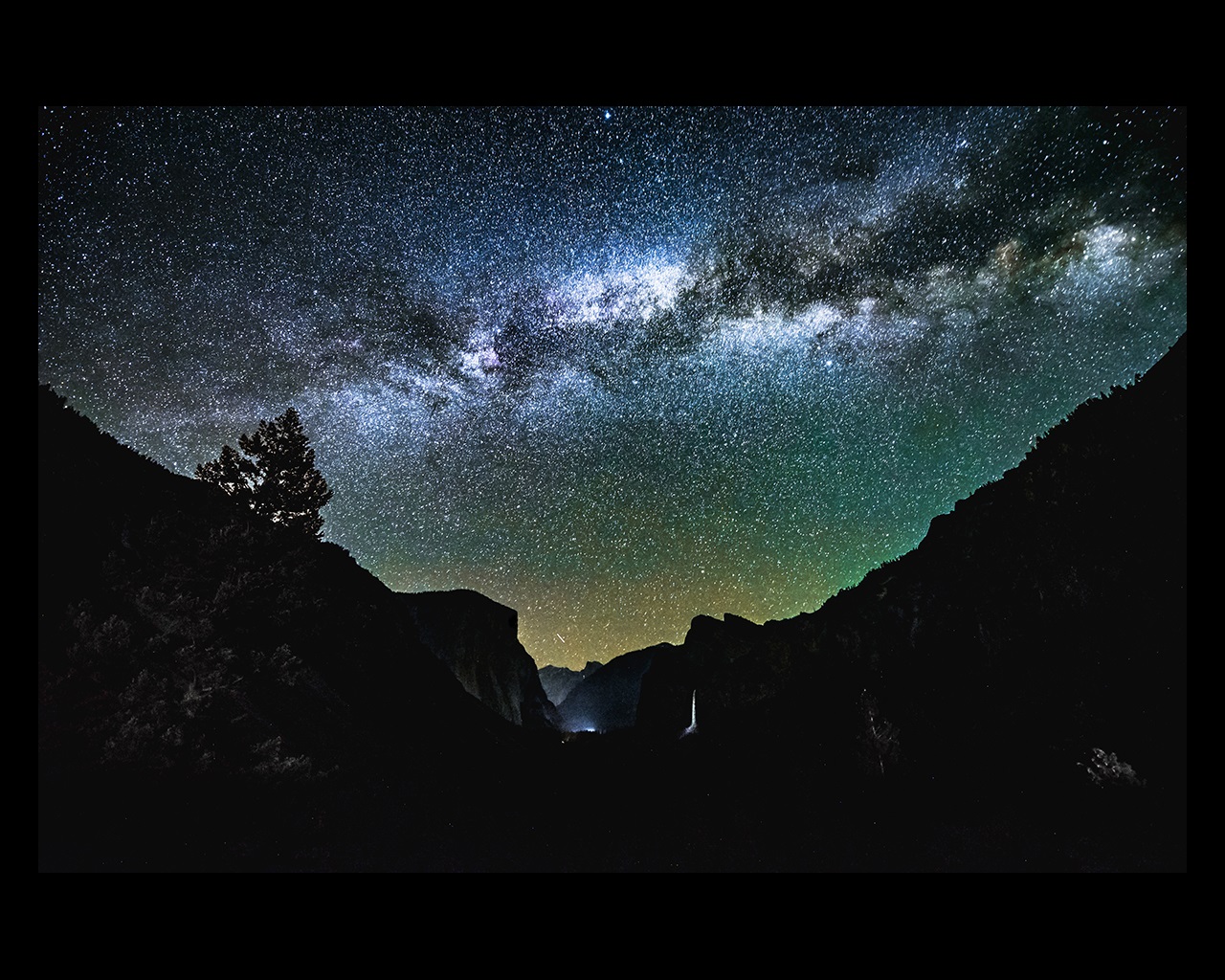 Mountains silhouetted against a starry night sky