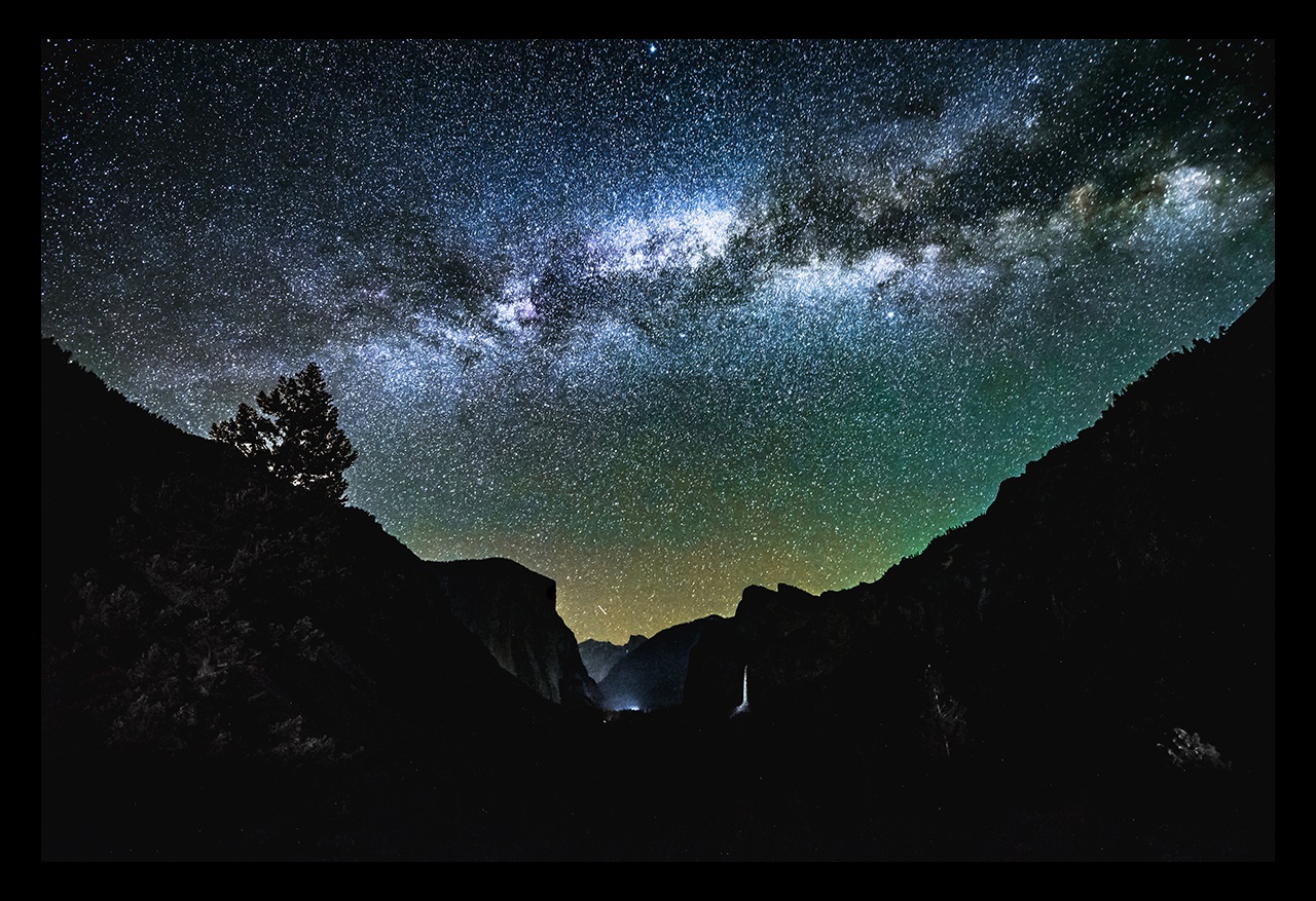 Mountains silhouetted against a starry night sky