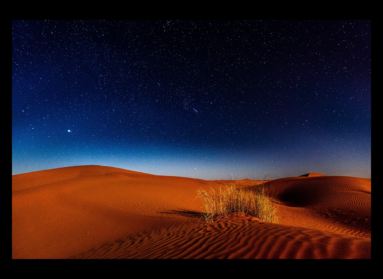 Nighttime stars over sandy desert dunes