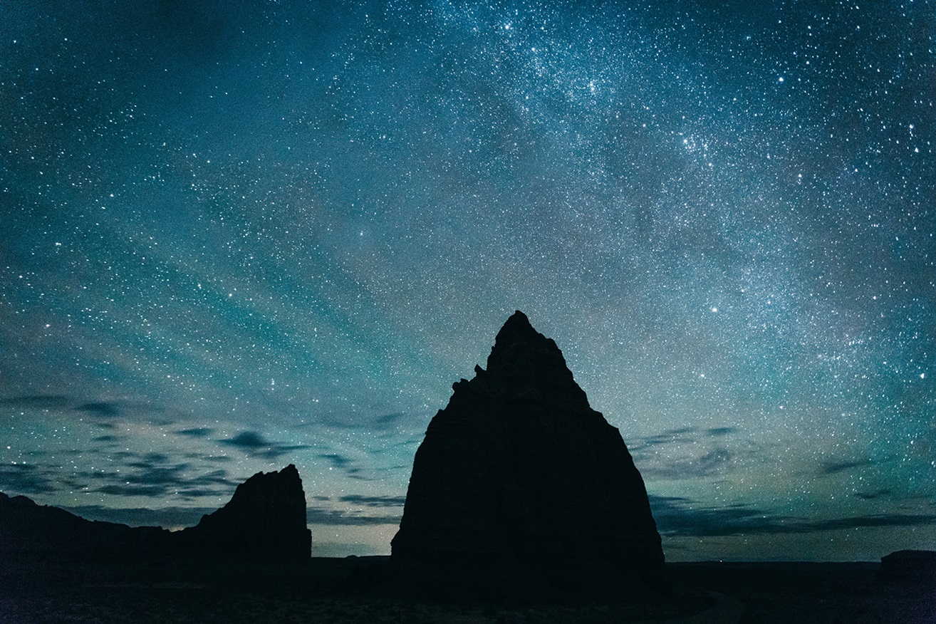 Rock formations silhouetted against a starry night
