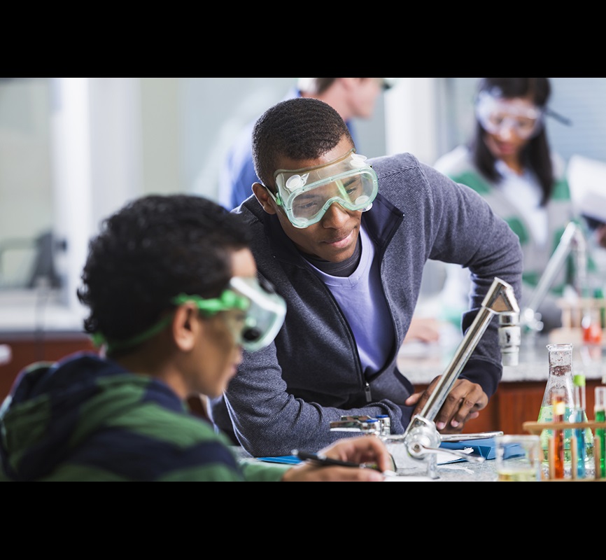 Teenage students in chemistry lab with safety goggles