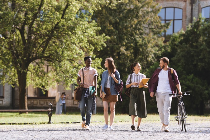 Small group of college students walking on a university campus on a sunny day