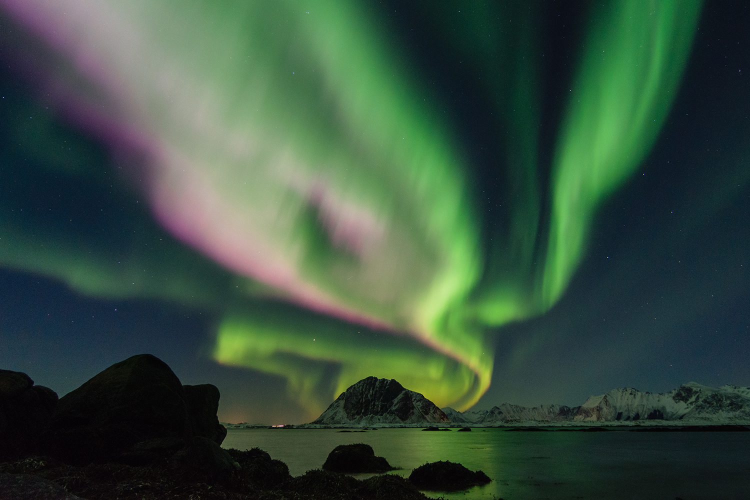Aurora borealis with snow covered mountains and water