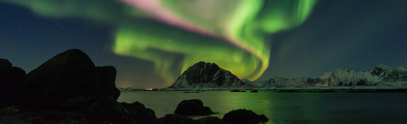 Aurora borealis with snow covered mountains and water