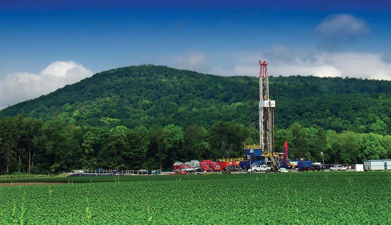 Shale drilling in front of green hill
