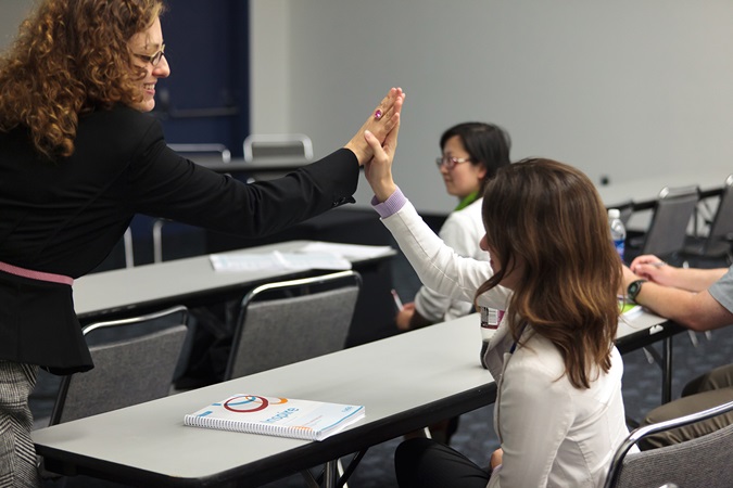 Teacher giving a student a high five in the classroom