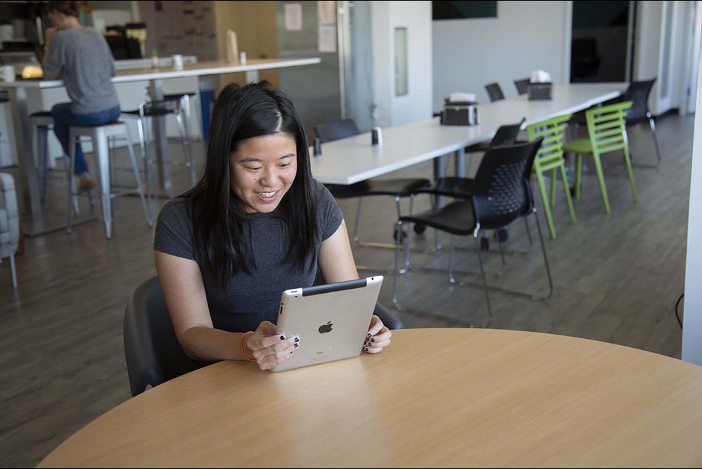 Woman smiling while holding ipad in office