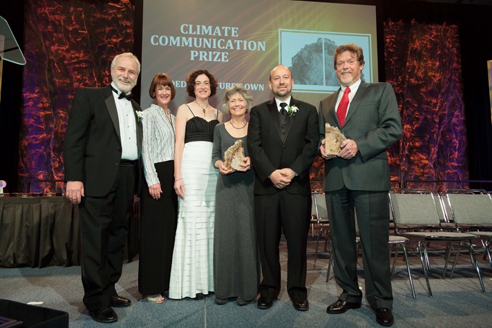 Group of people standing onstage at an awards ceremony