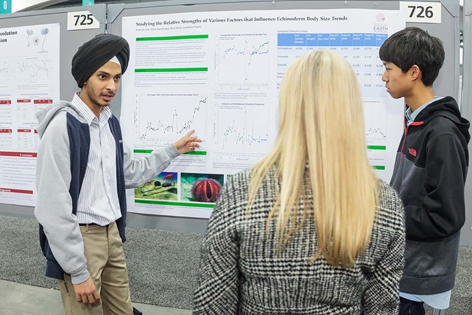 Student explaining poster to other students Student explaining poster to other students