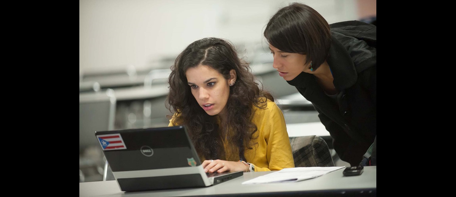 Teacher helping student on computer