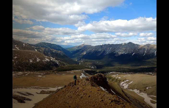 Woman standing on bluff look out over Yukon 