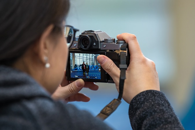 Close up of a woman pointing a camera