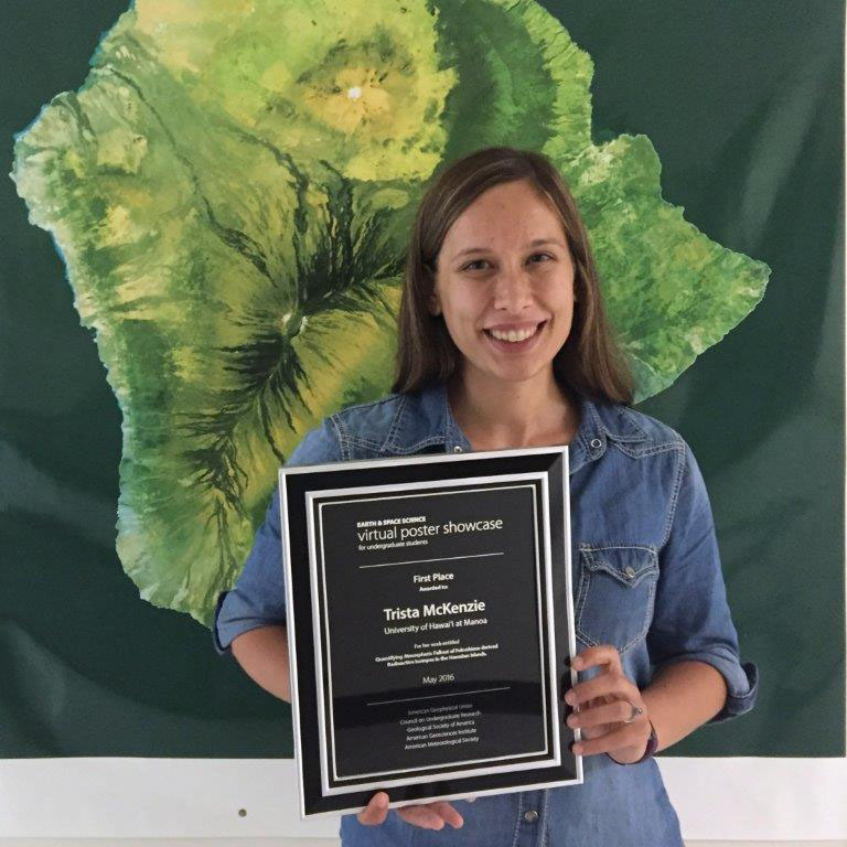 VPS winner Trista McKenzie stands in front of an image of Hawaii's Big Island holding her winner's plaque.
